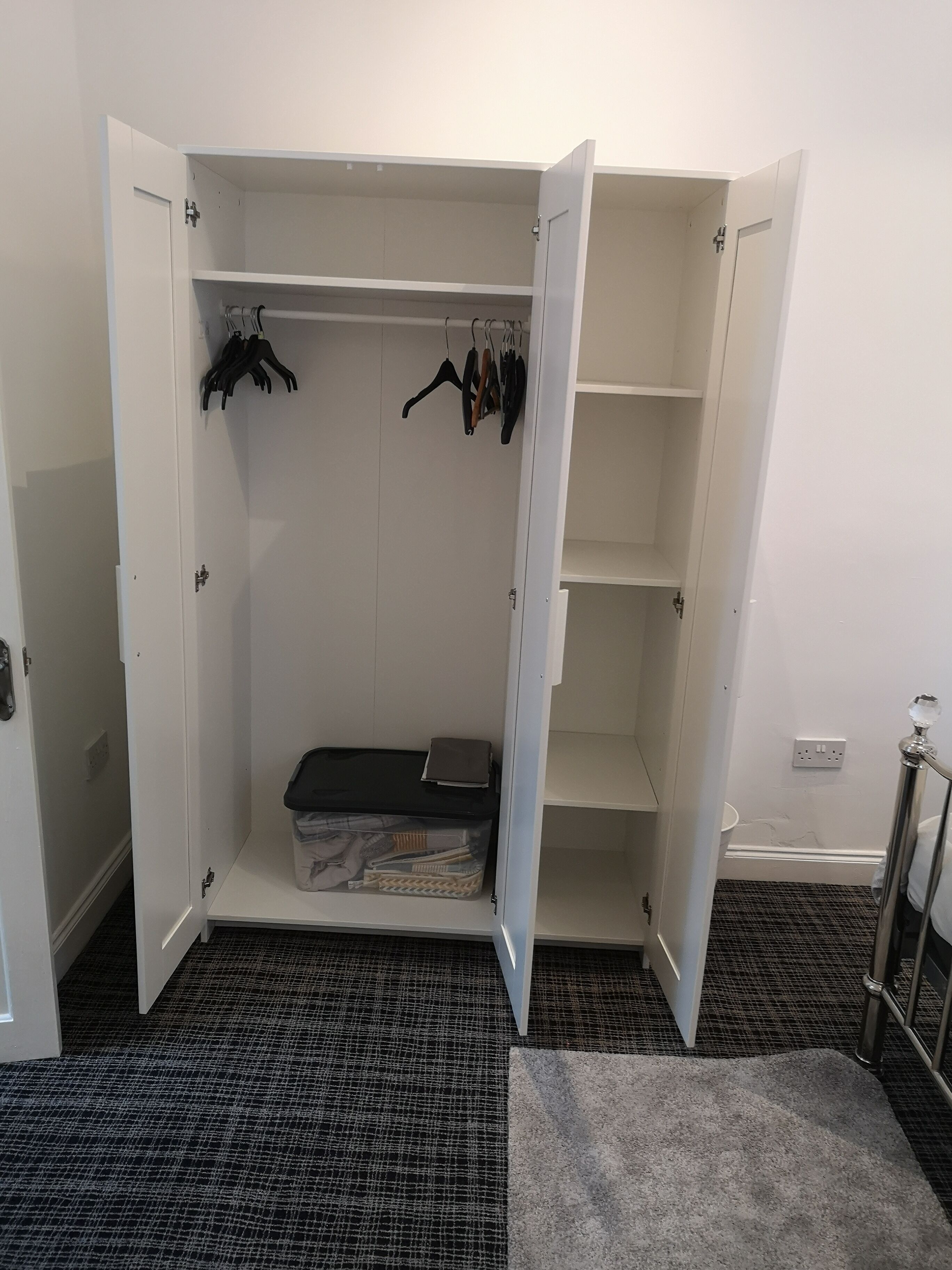 A walk-in closet with open doors, shelves, and hanging space.