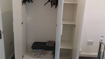 A walk-in closet with open doors, shelves, and hanging space.