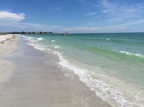 Una playa con agua turquesa cristalina y una orilla arenosa.