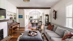 A spacious living room with a piano, a sofa, and a dining area in the background. - Tennessee Getaway (Jack Daniel’s, Nearest Green) (Shelbyville)