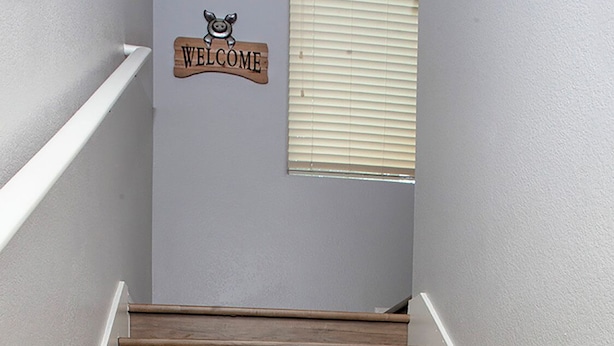 A wooden staircase with a 'WELCOME' sign above it.
