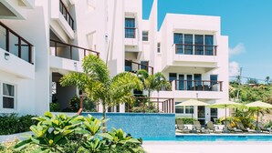 A modern hotel with multiple balconies, a swimming pool, and lush greenery. - #3-2BR Shalimar Vacation Townhouse, Frigate Bay, Saint Kitts. (Basseterre)
