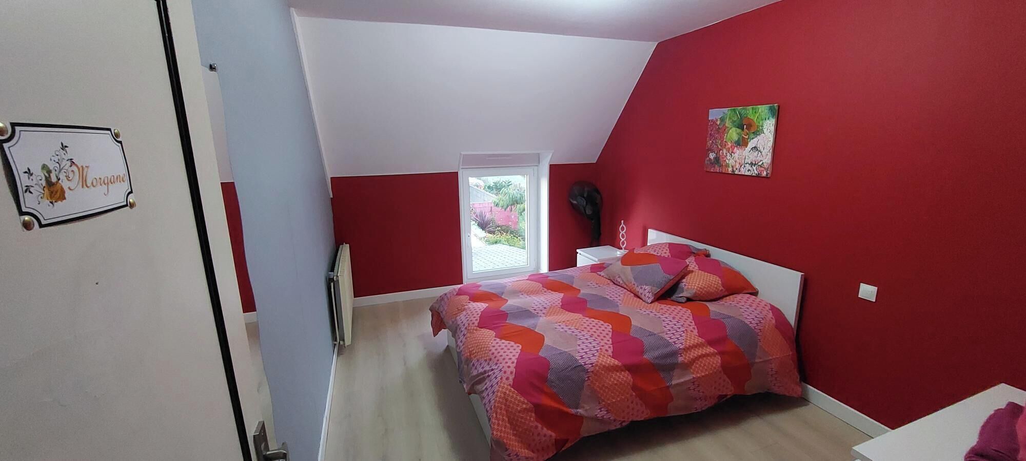 Une chambre à coucher avec un lit, un radiateur, une fenêtre et une porte.