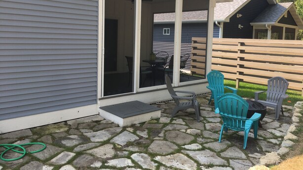 A patio area with stone flooring, outdoor furniture, and a sliding glass door leading to an interior space.