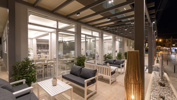 Een terras met witte meubels en een hoge decoratieve pilaar.