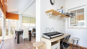 A modern kitchen with a wooden desk, a keyboard, and a stool.