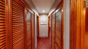 A hallway with wooden sliding doors and a framed map on the wall.