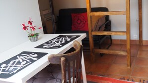 A bunk bed with a desk and chair, a red pillow, a lamp, and a small plant. - Beau Studio Bien Équipé (Le Pré-Saint-Gervais)