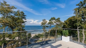 A balcony with a clear view of the sea and trees. - Apartment with Balcony | Pool, Spa and Jacuzzi, 100 m to the Beach (Rewal)