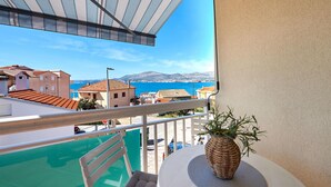 Un balcon avec vue sur la mer et les bâtiments.