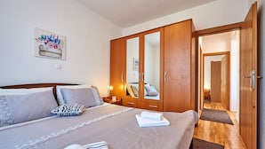 Une chambre à coucher avec un grand lit, une armoire et un miroir.