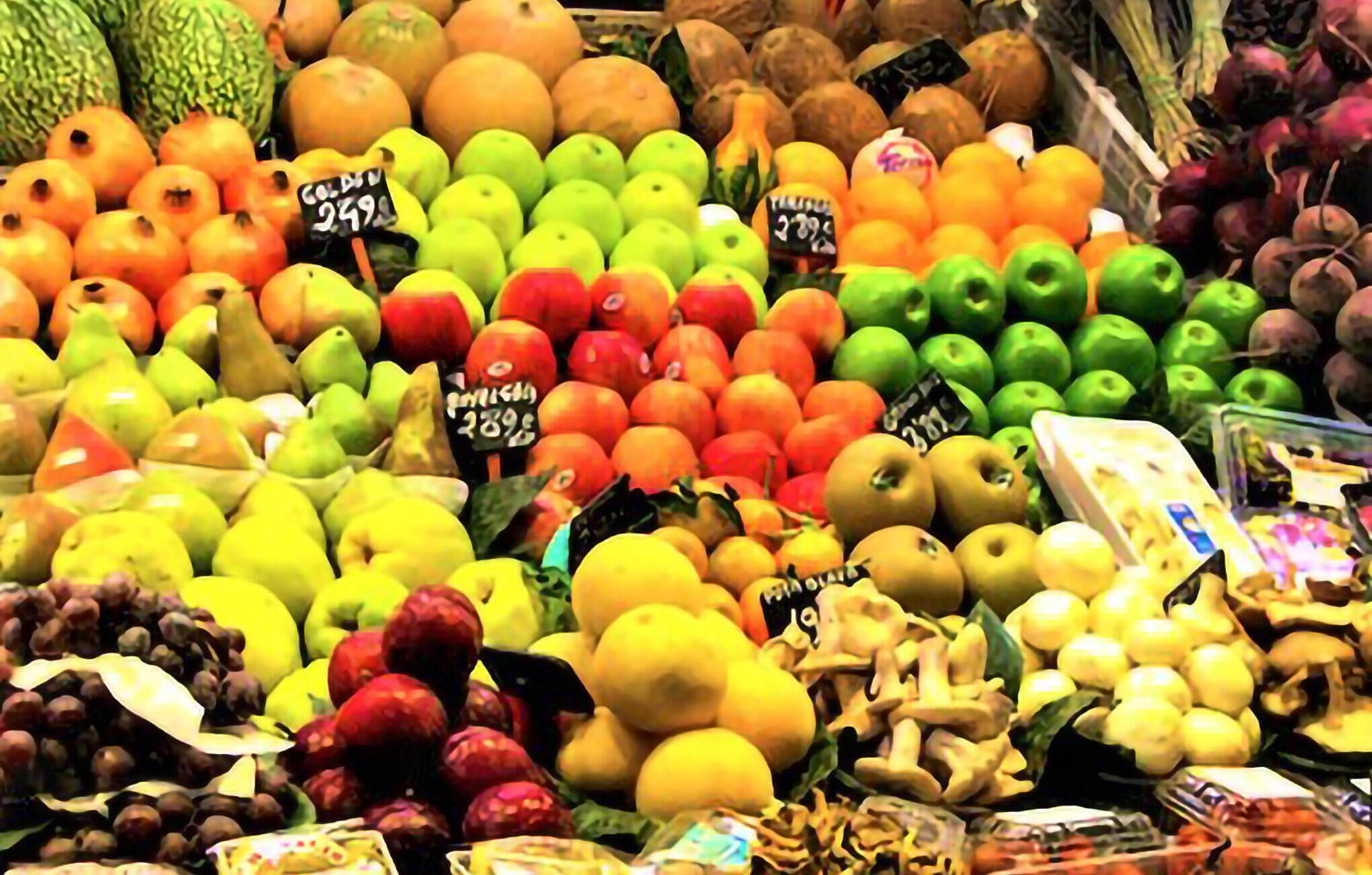 A variety of fruits and vegetables displayed in a market setting.