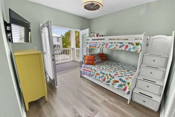 A room with a bunk bed, a small yellow cabinet, and a balcony. - 6 Seater Golf Cart, 3 Bikes, Easy walk to Beach! (Santa Rosa Beach)