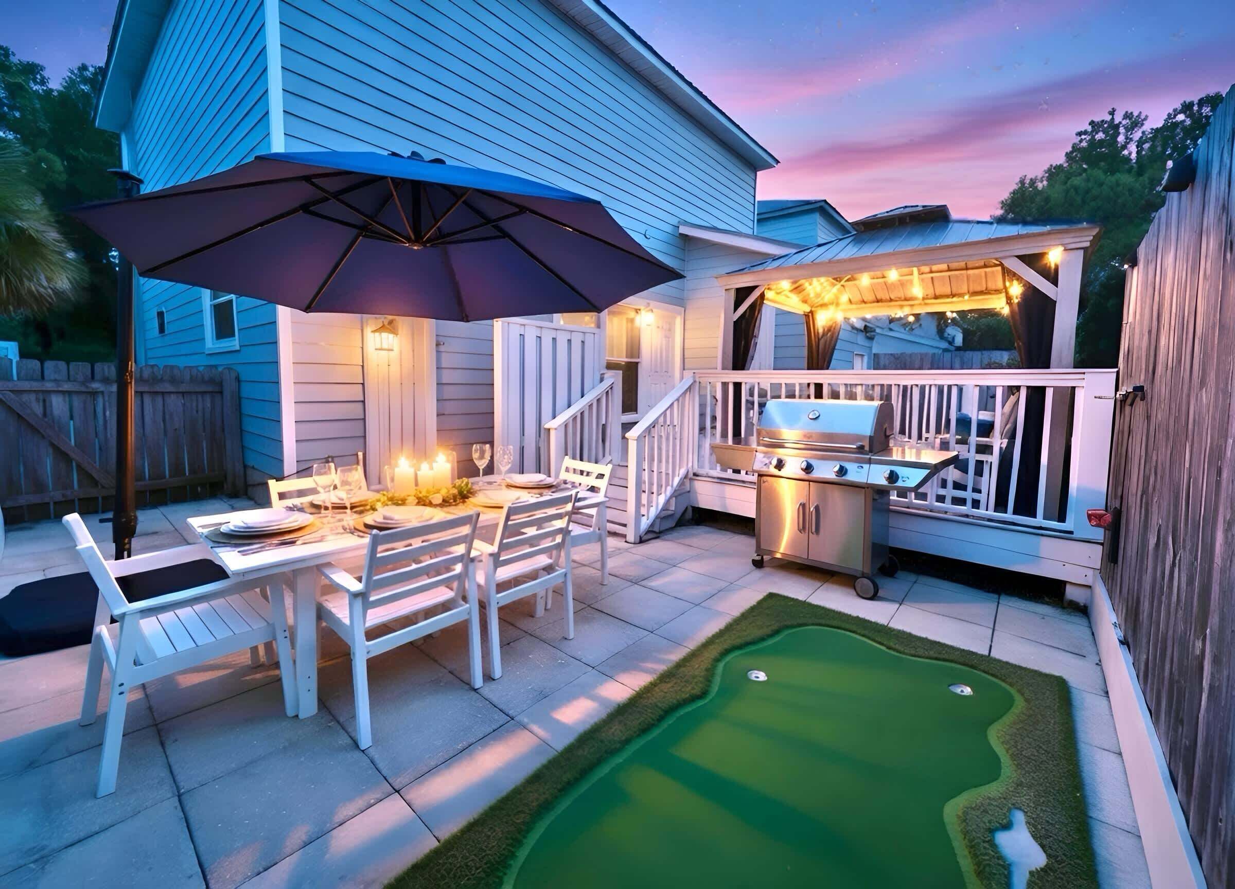 An outdoor patio with a dining table, chairs, a grill, and a small putting green.