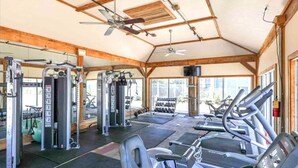 Ein Fitnessstudio mit Laufbändern, Kraftgeräten und Kurzhanteln.