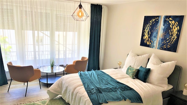 Une chambre moderne avec un grand lit, une table ronde et deux chaises.