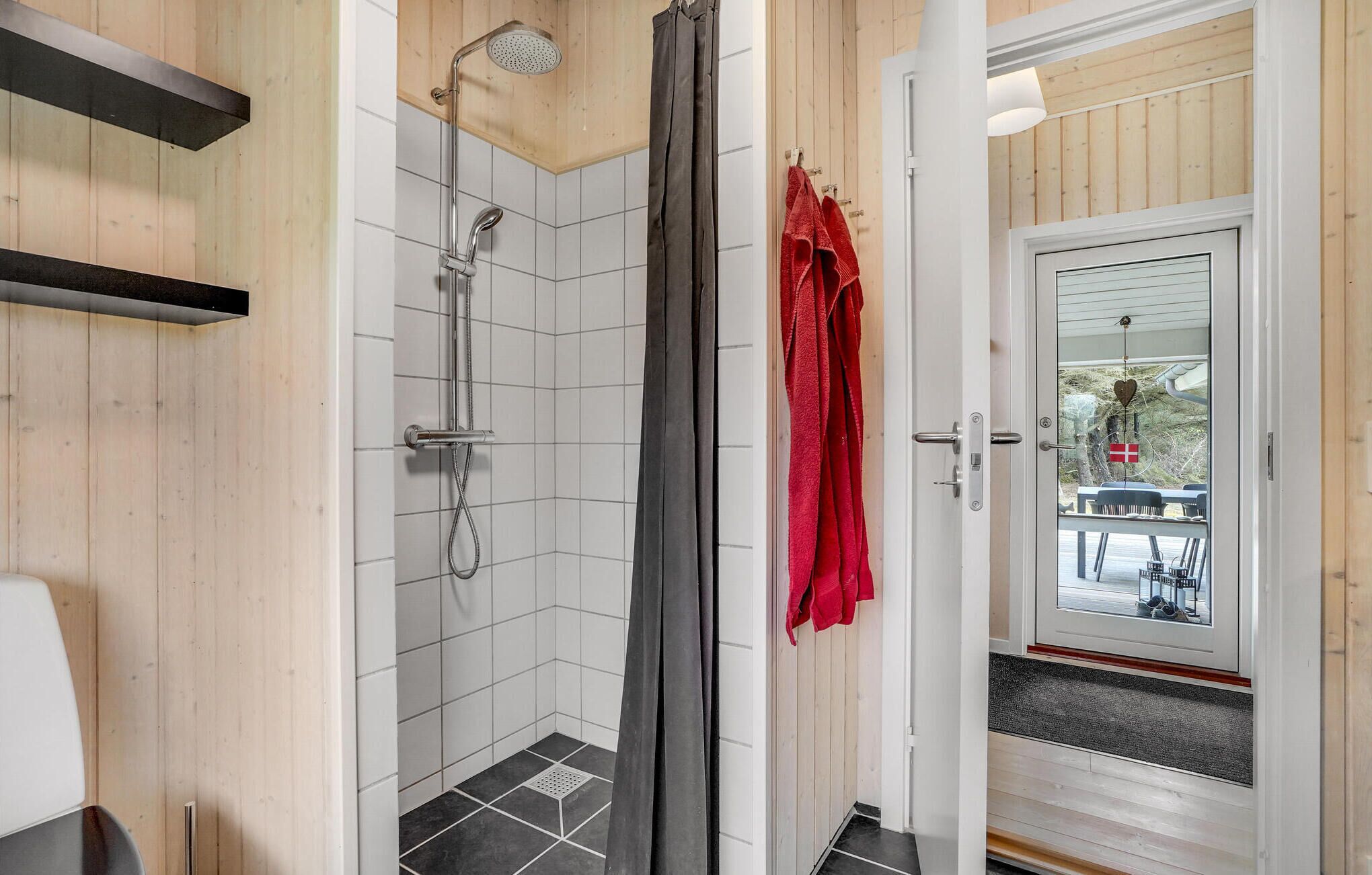 A shower with a rain showerhead and a grey curtain.