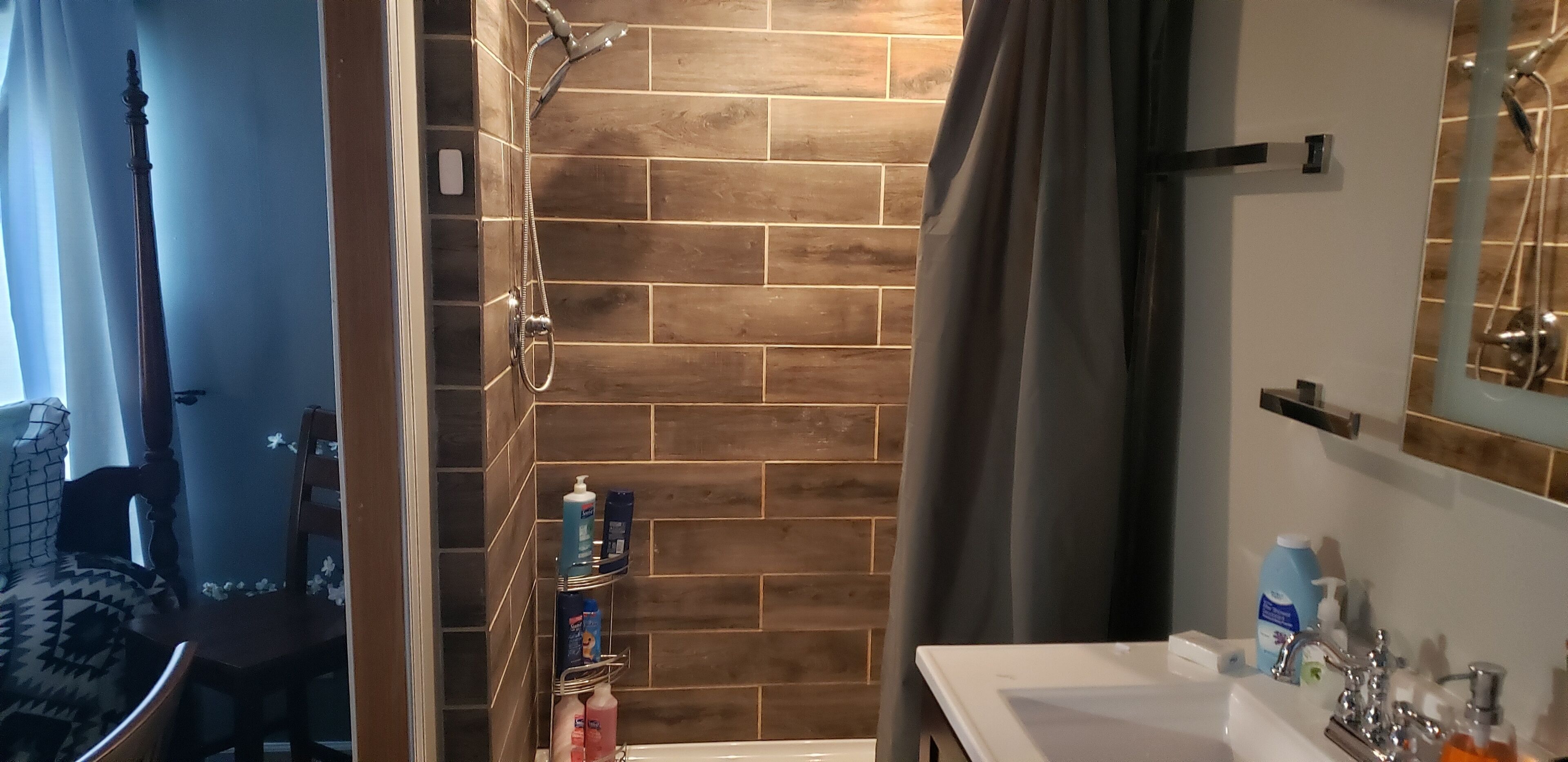 A bathroom with a shower, a sink, and a mirror.