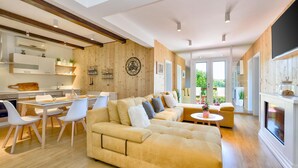 A modern living room with a large sofa, dining area, and kitchen. - Cozy home in Mrzlo Polje with sauna (Mrzlo Polje)
