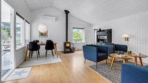 Un salon moderne doté d’une cheminée, d’un coin repas et d’un espace salon confortable.