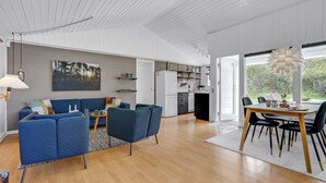 Un espace de vie moderne comprenant un canapé, une table à manger et un coin cuisine.