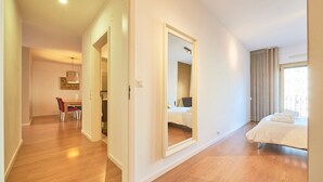 Una habitación de hotel con cama, baño y zona de comedor.