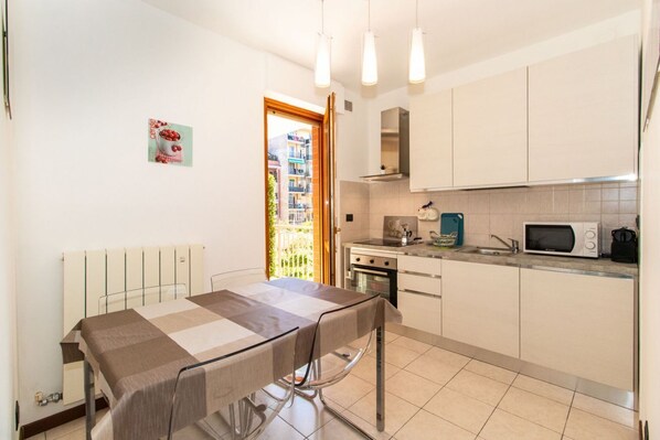 A compact kitchen with a dining table, a microwave, and a stove.