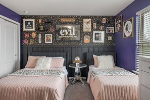 A bedroom with two beds, a wall decorated with various framed pictures and a sign that says "evil just sounds more fun!" - Closest House to Resort • Star Wars Adventure + Home Theater! (Kissimmee)