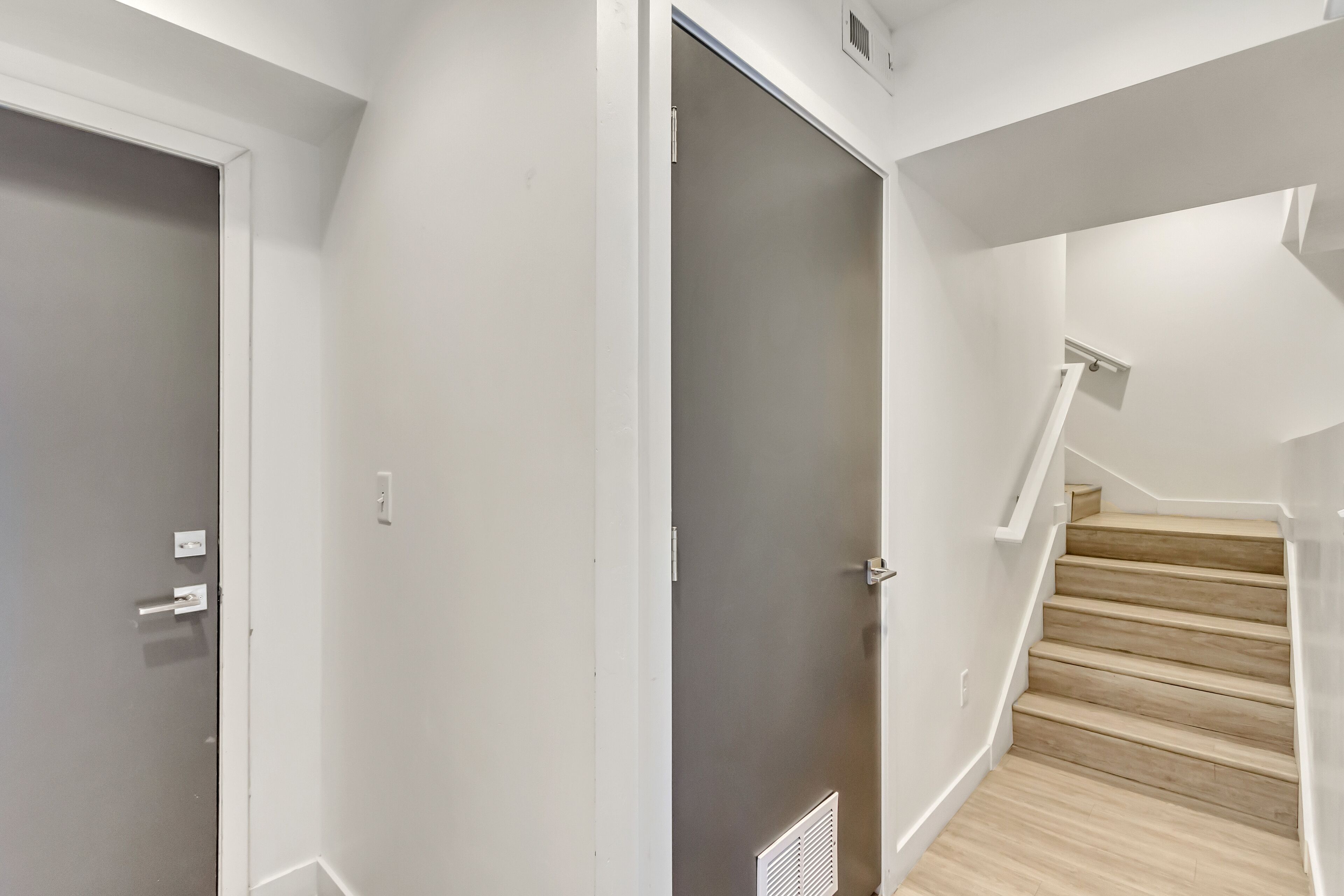 A staircase with wooden steps and white walls.