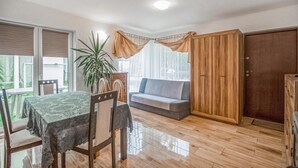 Un comedor con una mesa, sillas, un sofá y una planta en maceta.