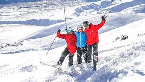 A snowy mountain landscape with three skiers posing for a photo. - Matariki Star - 1 Bedroom Suite A (Lake Tekapo)