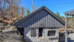 A small stone building with a wooden roof, a plaque, and a metal gate. - Beautiful apartment in Risør with WiFi (Risør)