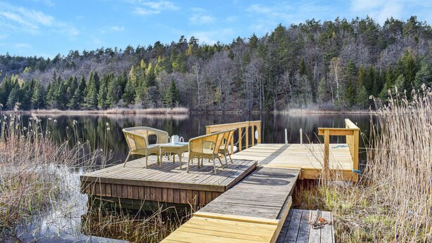 A wooden dock extending into a calm lake, surrounded by dense forest. - Beautiful apartment in Risør with WiFi (Risør)