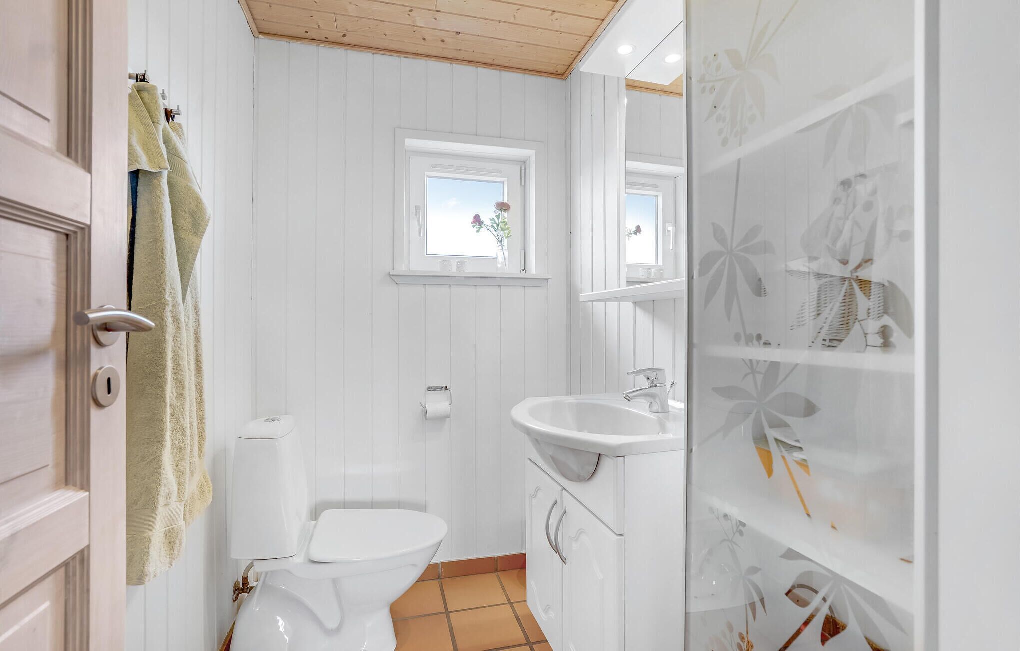 Ein Badezimmer mit Toilette, Waschbecken und einem Fenster.