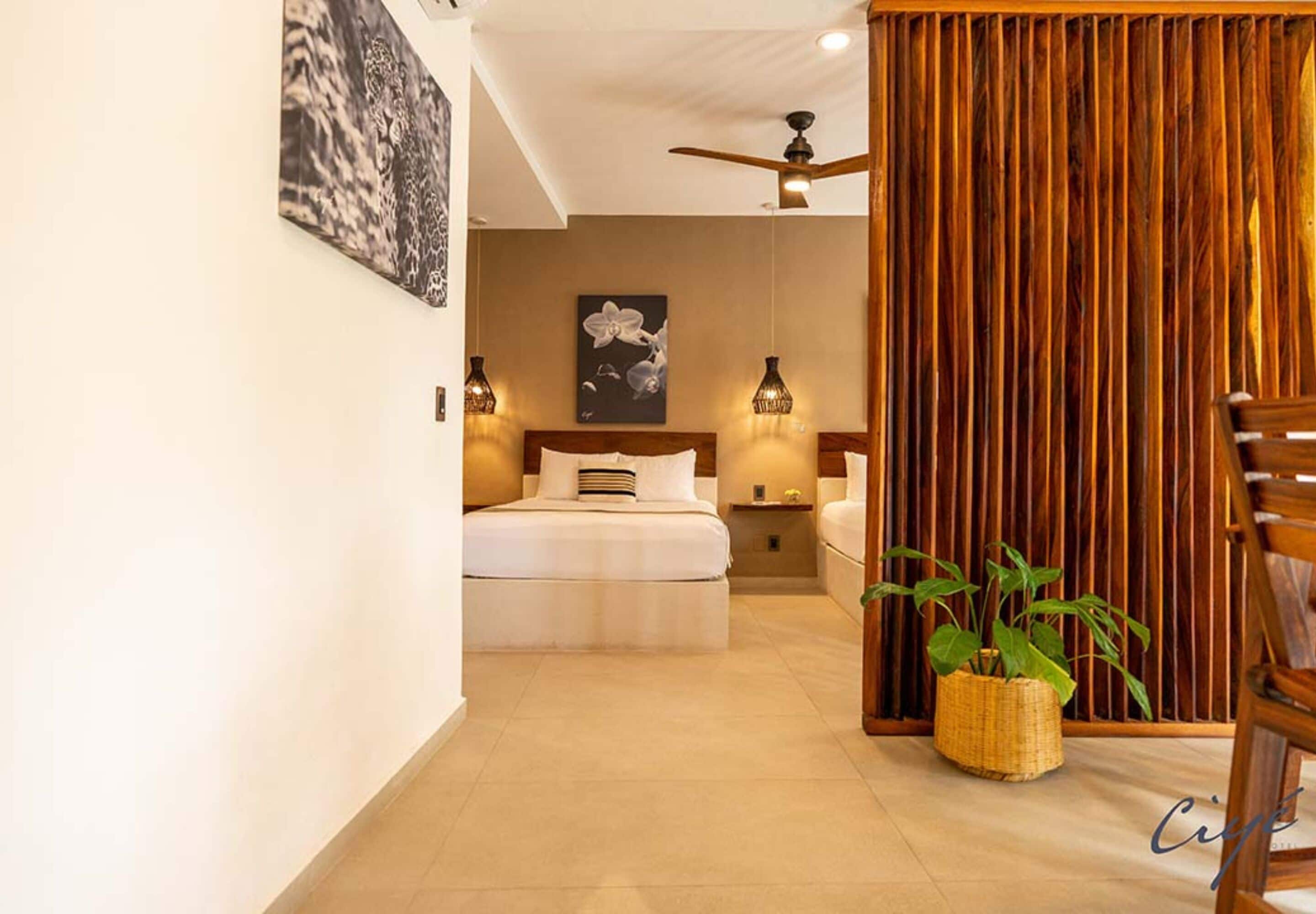 Une chambre moderne avec un grand lit, des tables de chevet, un ventilateur de plafond et une cloison en bois.