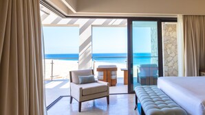 A hotel room with a balcony, a bed, a chair, and a table. - Largest Terrace on the Ocean in Cabo! SUPER PENTHOUSE w/ 4,500 sq ft Terrace!! (Los Cabos)