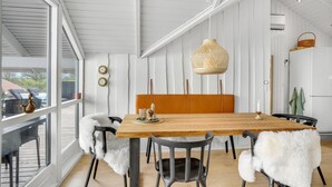 En matplats med ett träbord, stolar och en hängande lampa.
