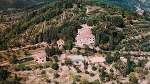 Vue aérienne d’un domaine rural comprenant un grand bâtiment, une piscine et une végétation luxuriante.