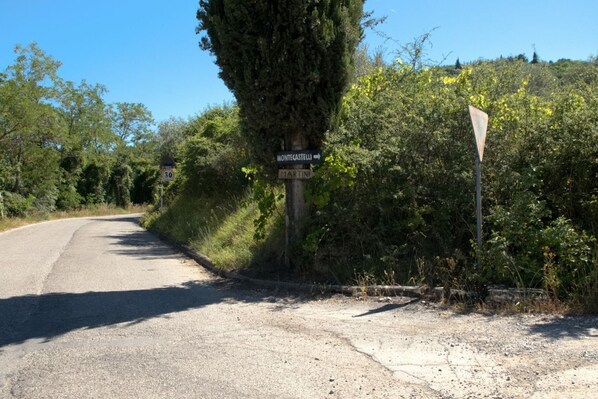 A rural road with a signpost indicating directions to Montecastelli and Martini.