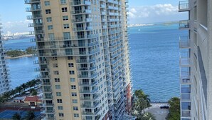 A high-rise building with multiple balconies overlooking a coastal area.