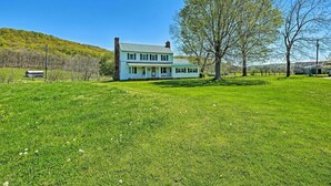 A two-story house with a large front porch and a well-maintained lawn.