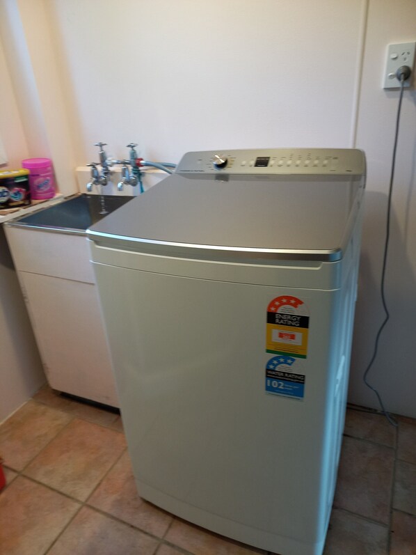 A compact, white refrigerator with a digital control panel and energy efficiency stickers.