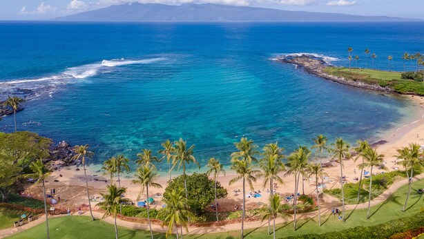 A tropical beach with clear blue waters, palm trees, and a distant mountain range. - Luxury Ocean View Kapalua Golf Villa, Walk to Kapalua Bay, 3BR/2BA (Lahaina)