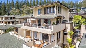 A multi-story residential building with a balcony, large windows, and a view of a forested area. - Luxury Ocean View Kapalua Golf Villa, Walk to Kapalua Bay, 3BR/2BA (Lahaina)