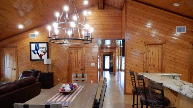 A log cabin interior with a dining area, a bar, and a living room. - Hotel luxury in a Log Cabin (Rockport)