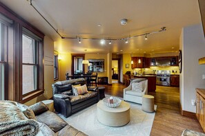 Relax in a spacious living area with a comfortable seating area, central coffee table, and dining space for four.