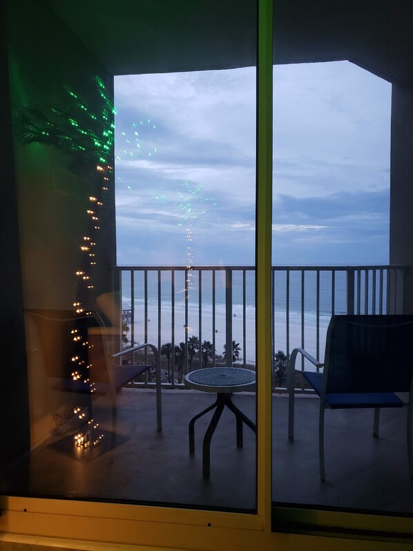 Un balcón con vistas al mar, una mesa y sillas.