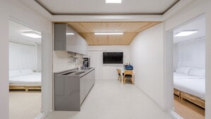 A compact hotel room with a kitchenette, a single bed, and a small table with chairs. - Gyeongju Nenugnam20 Hanok Pension (Gyeongju)