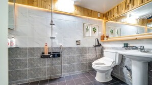 A modern bathroom with a shower, toilet, and sink.