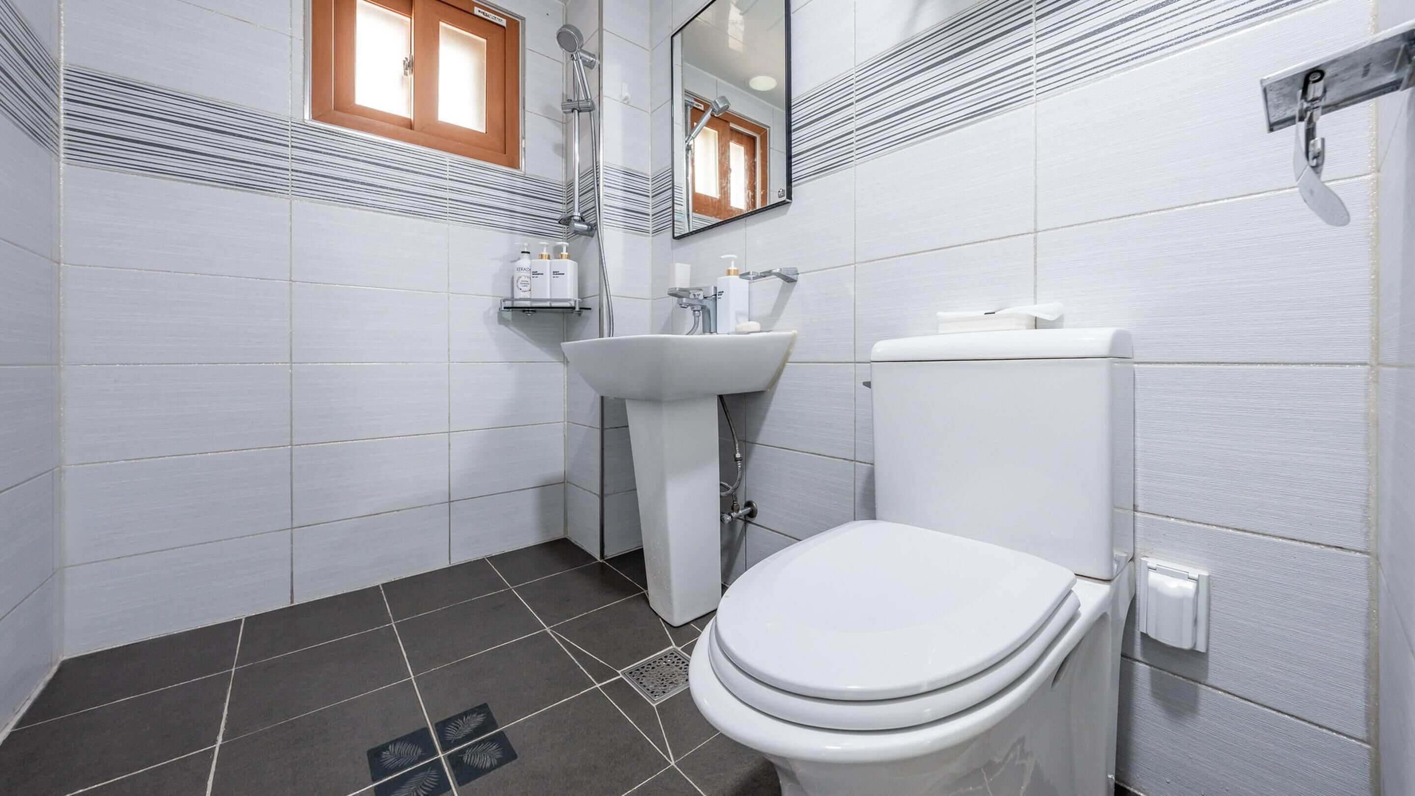 Ein modernes Badezimmer mit Toilette, Waschbecken und Dusche.